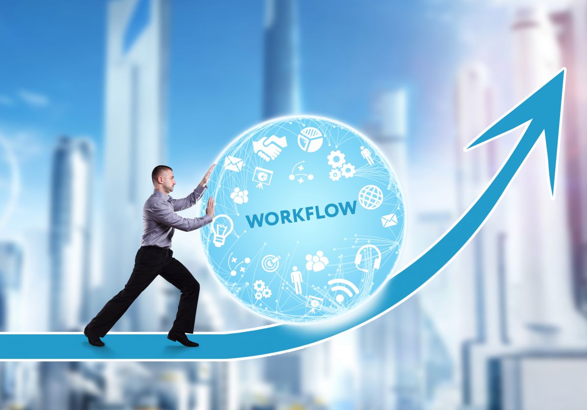 Image of man pushing large sphere that says workflow up a hill